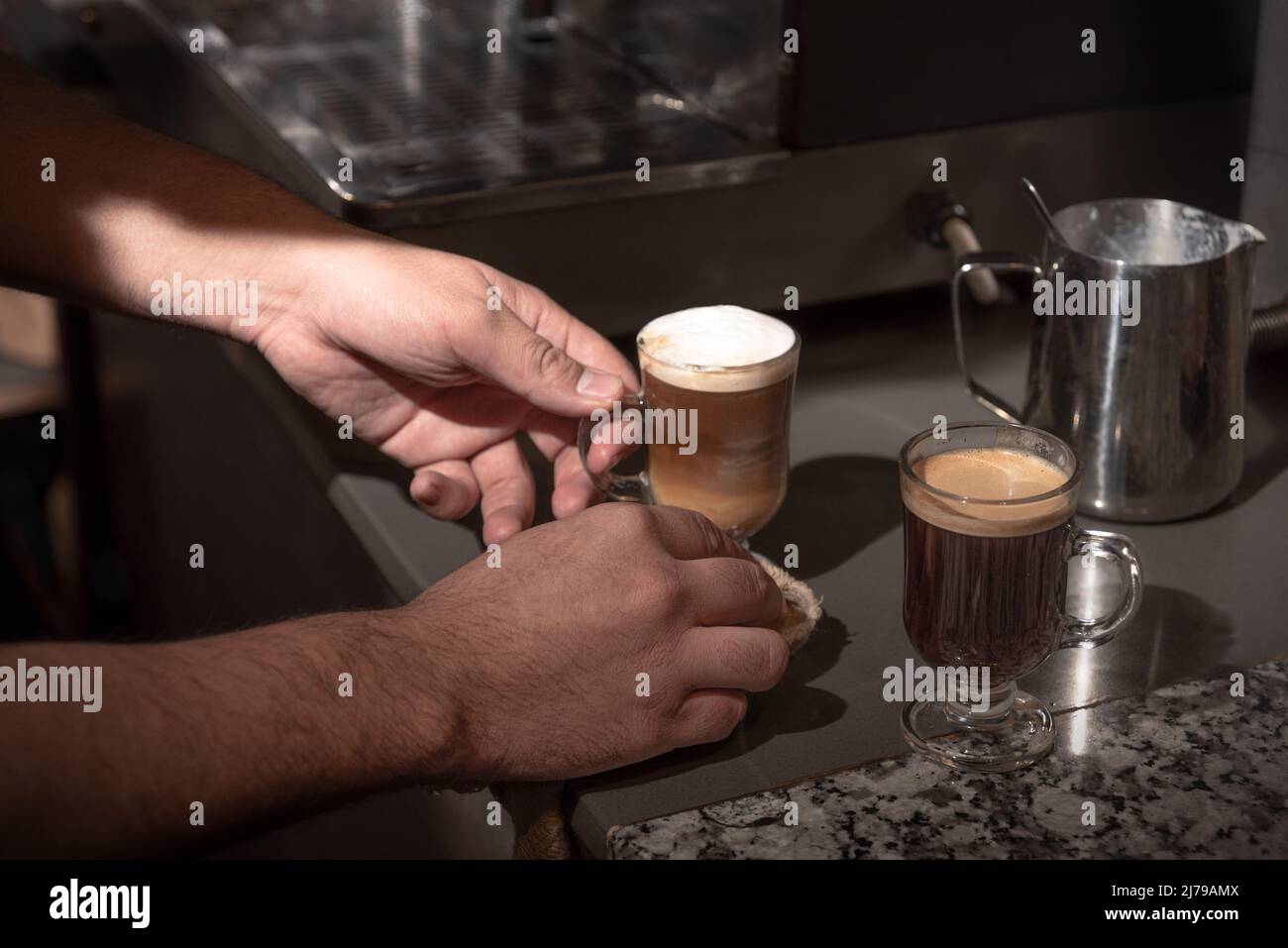 Zwei Kaffees an einer Theke zubereiten. Mann Hände. Horizontal. Farbe. Stockfoto