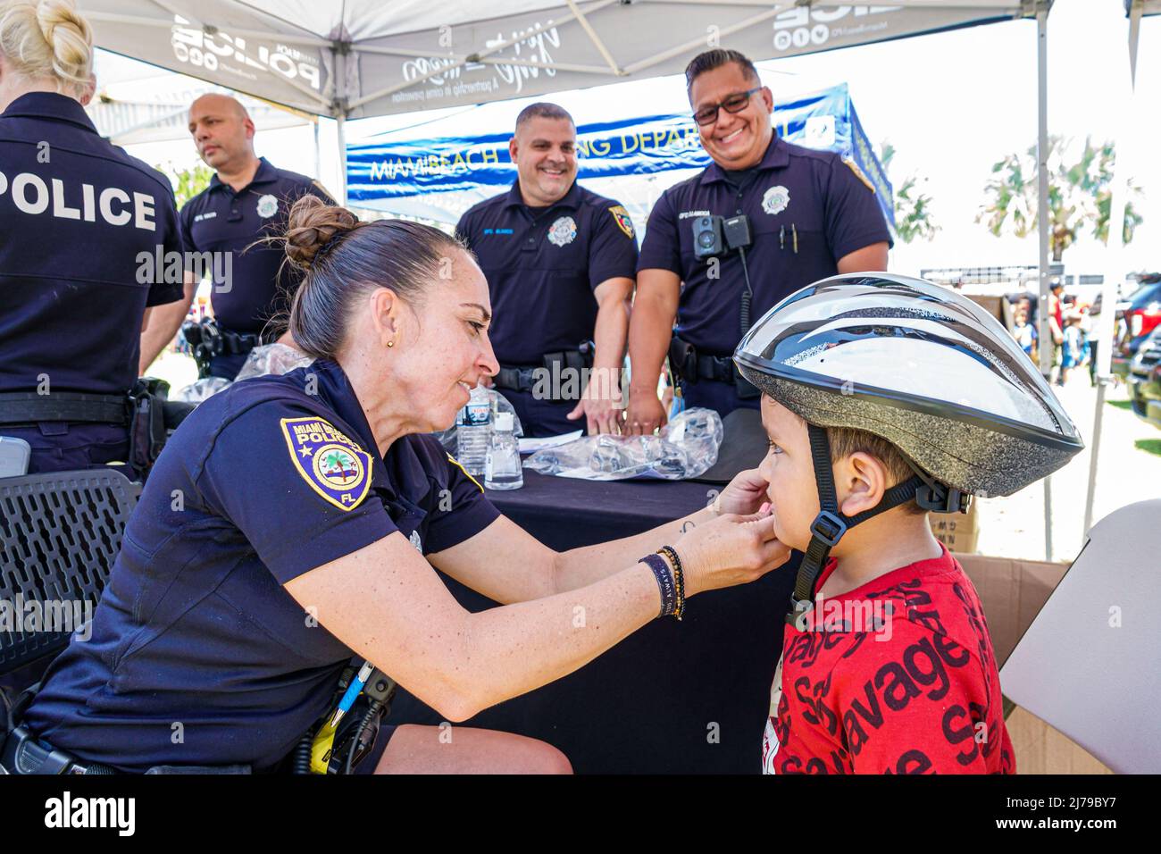 Miami Beach Florida jährliche Miami Beach Police Block Party Familie kostenlose Veranstaltung Flamingo Park Fahrrad Helm Giveaway frei passenden Jungen Polizeioffizier poli Stockfoto