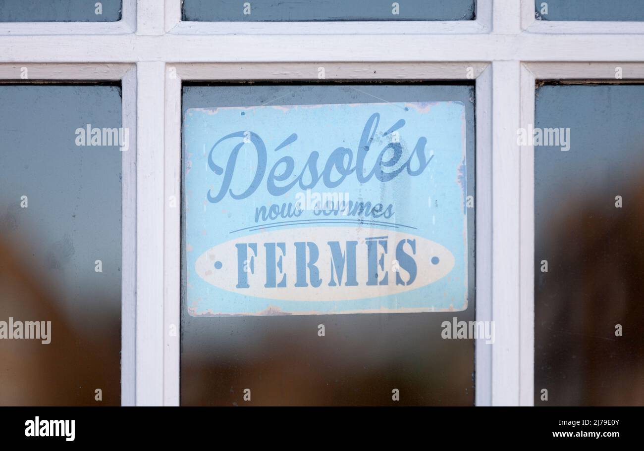 Nahaufnahme auf einem geschlossenen Schild mit der Aufschrift „Désolés, nous sommes fermés“ auf Französisch, was auf Englisch „Sorry we are closed“ bedeutet. Stockfoto