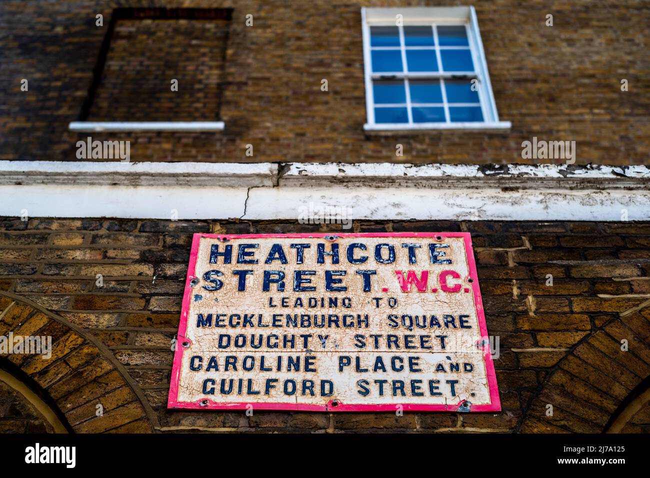 Heathcote Street WC London Street Sign - Vintage London Street Sign in Richtung Heathcote Street, die zum Meckenburgh Square, Doughty St, Caroline Place führt. Stockfoto