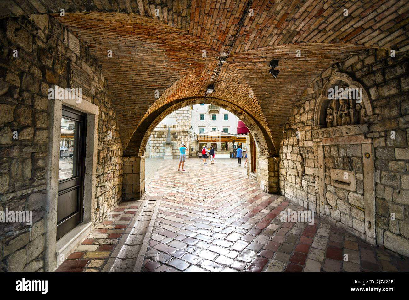 Das Quadrat der Arme öffnet sich vor wie Touristen die gated, ummauerten mittelalterlichen Festung Stadt Kotor, Montenegro geben Sie über den Tunnel Eingang Stockfoto