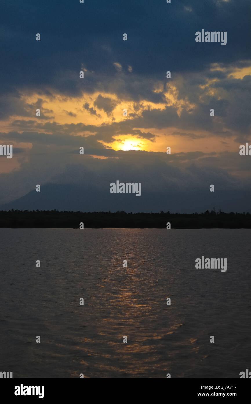 Fluss mit Berghintergrund und Sonnenuntergang am Abend Stockfoto