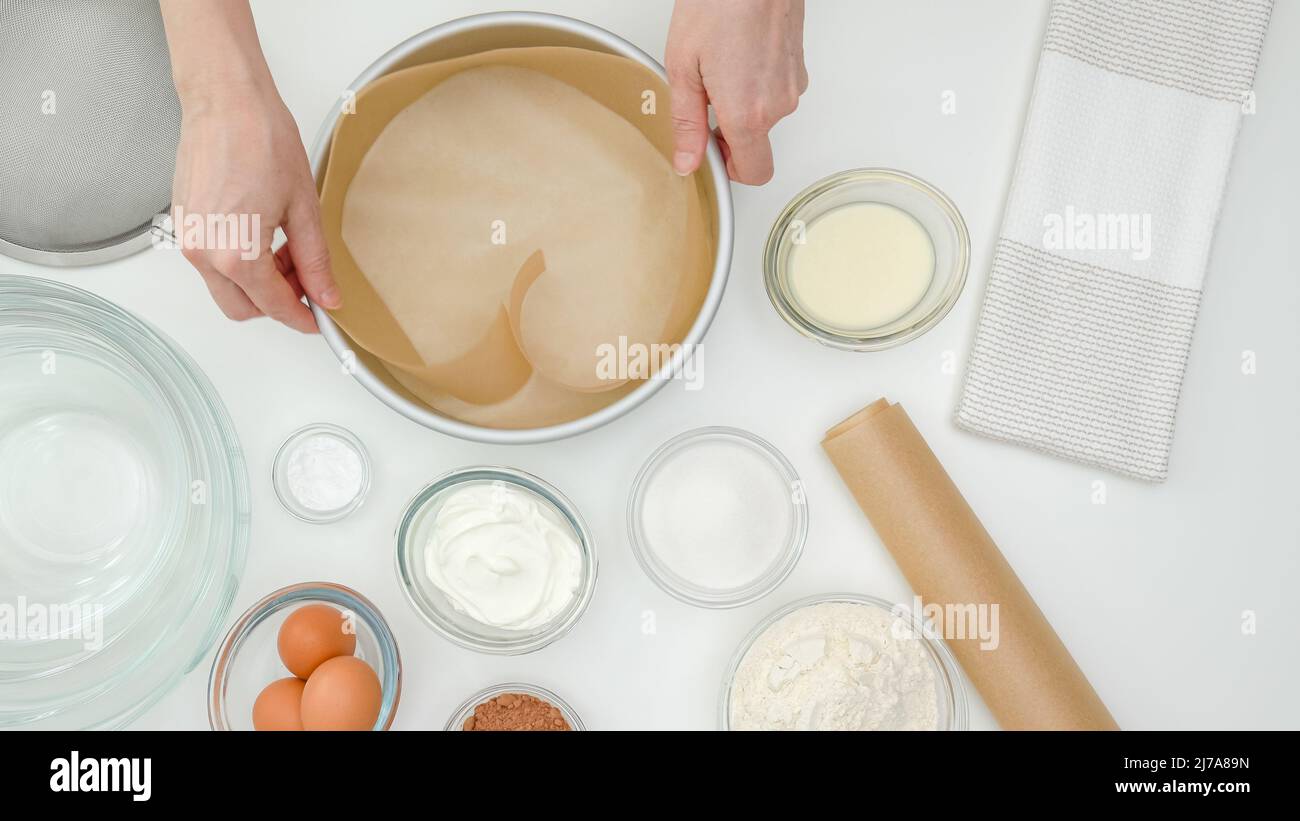 Zutaten, Geschirr, Pergamentpapier Nahaufnahme auf Küchentisch, Blick von oben. Schritt für Schritt Schokoladenkuchen Rezept, Frau Hände Stockfoto