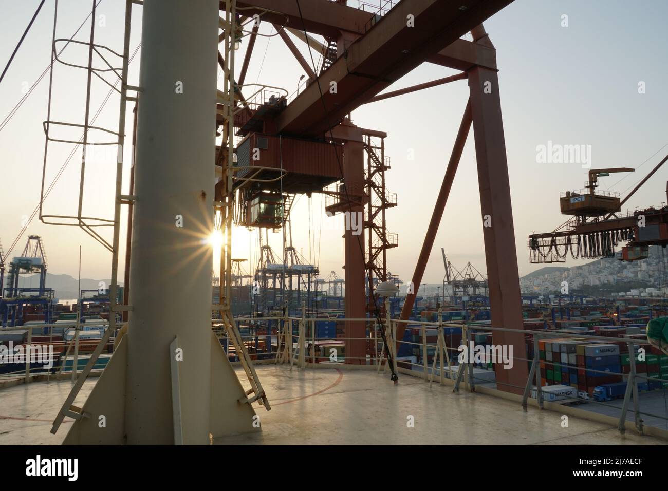 Blick vom Schiff auf den Hochbau großer Portalkrane in horizontaler Position, die auf den Frachtbetrieb der Containerschiffe in Piräus, Griechenland, warten. Stockfoto