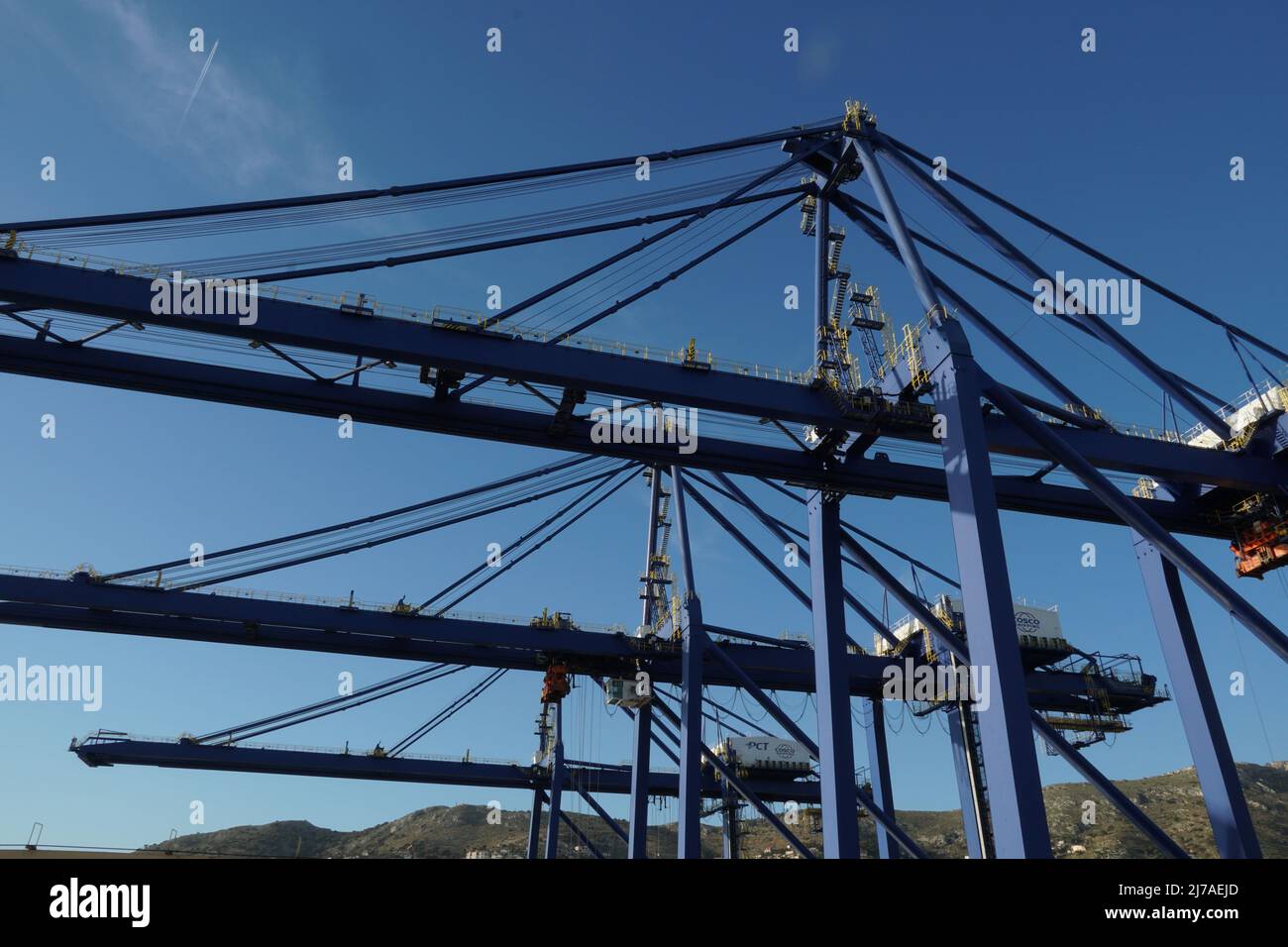Hoher Bau von blauen großen Portalkranen in horizontaler Position erwartet Frachtbetrieb der Containerschiffe im Hafen von Piräus, Griechenland unter cl Stockfoto