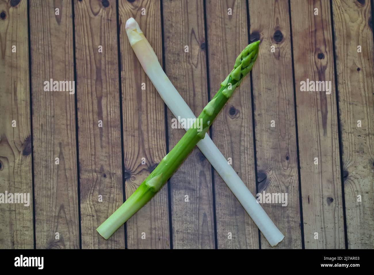 Neue Ernte von weißem und grünem deutschen Spargel, Bund roher grüner und weißer Spargel im Korb mit Holzhintergrund Stockfoto