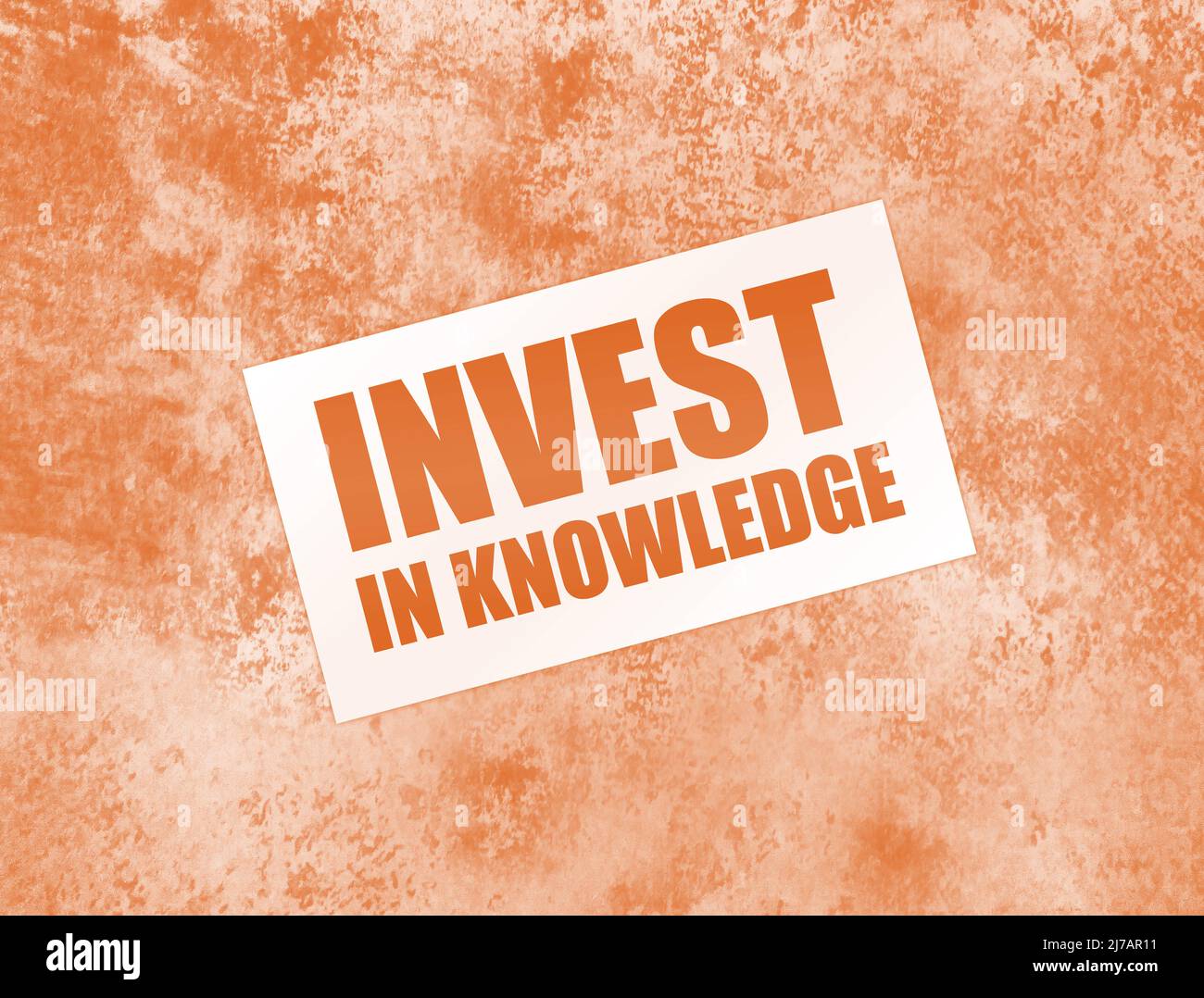 Investieren Sie in Wissenswörter auf der Karte auf dem Holztisch. Business Education Konzept. Stockfoto