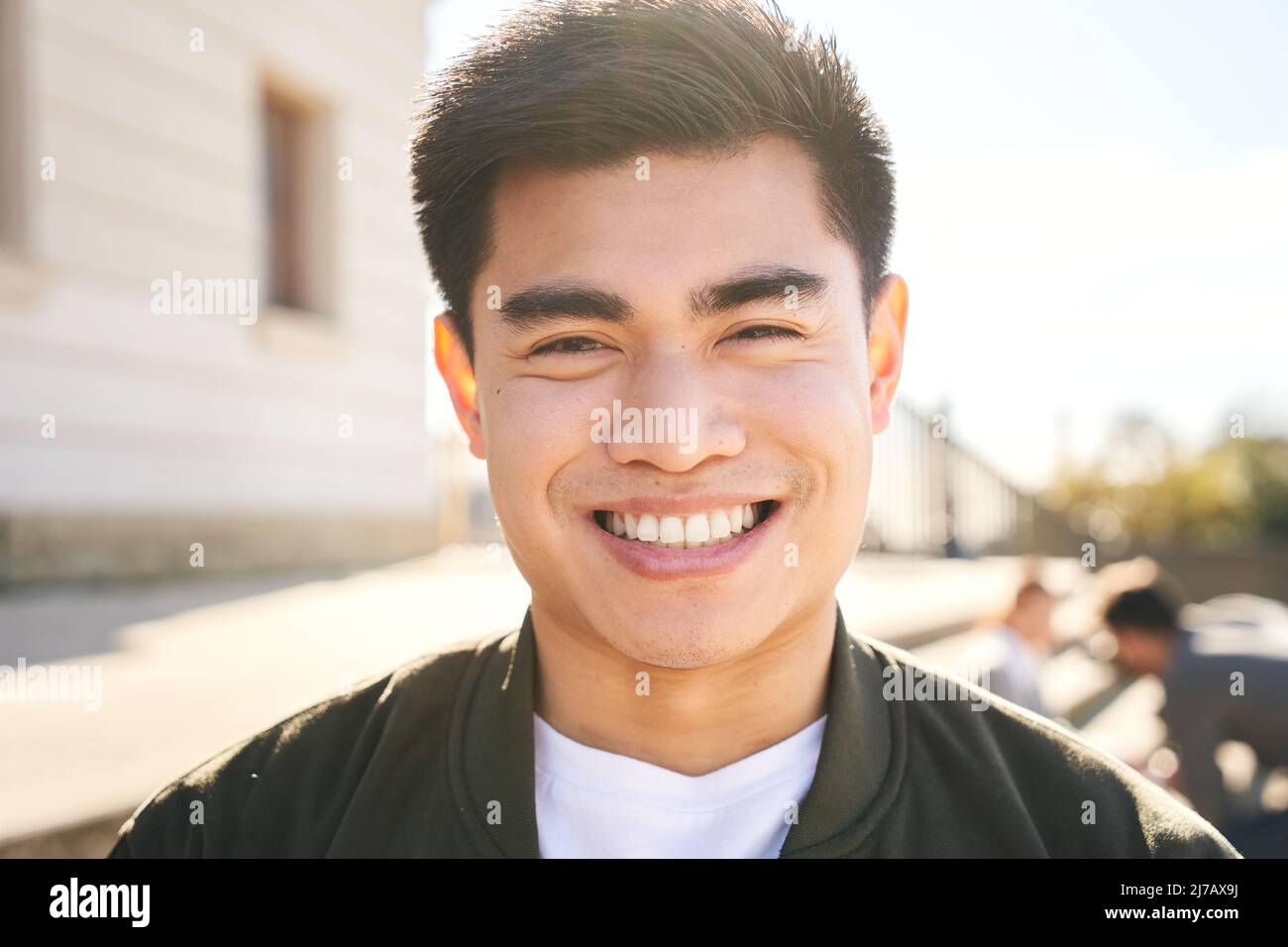 Außenportrait eines lächelnden Chinesen, der die Kamera anschaut und mit positivem Gesicht und freundlichem Aussehen lacht. Nahaufnahme eines glücklichen menschlichen Gesichts - Stockfoto