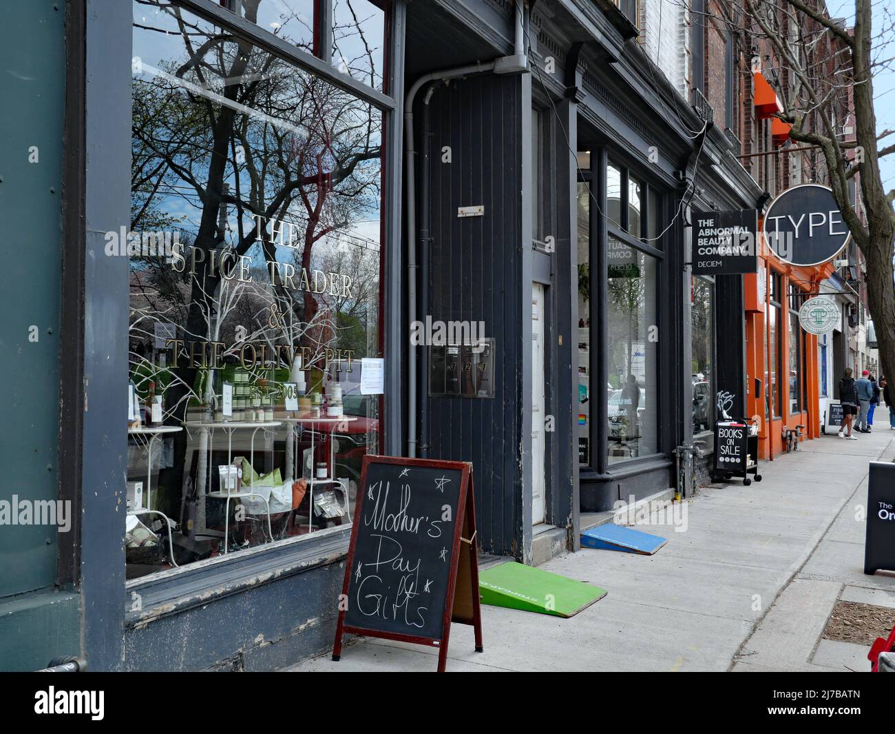 Toronto, Ontario, Kanada - 6. Mai 2022: Ältere Stadtteile von Toronto wie die Queen Street West erhalten unabhängige Geschäfte, die echten Charakter haben Stockfoto
