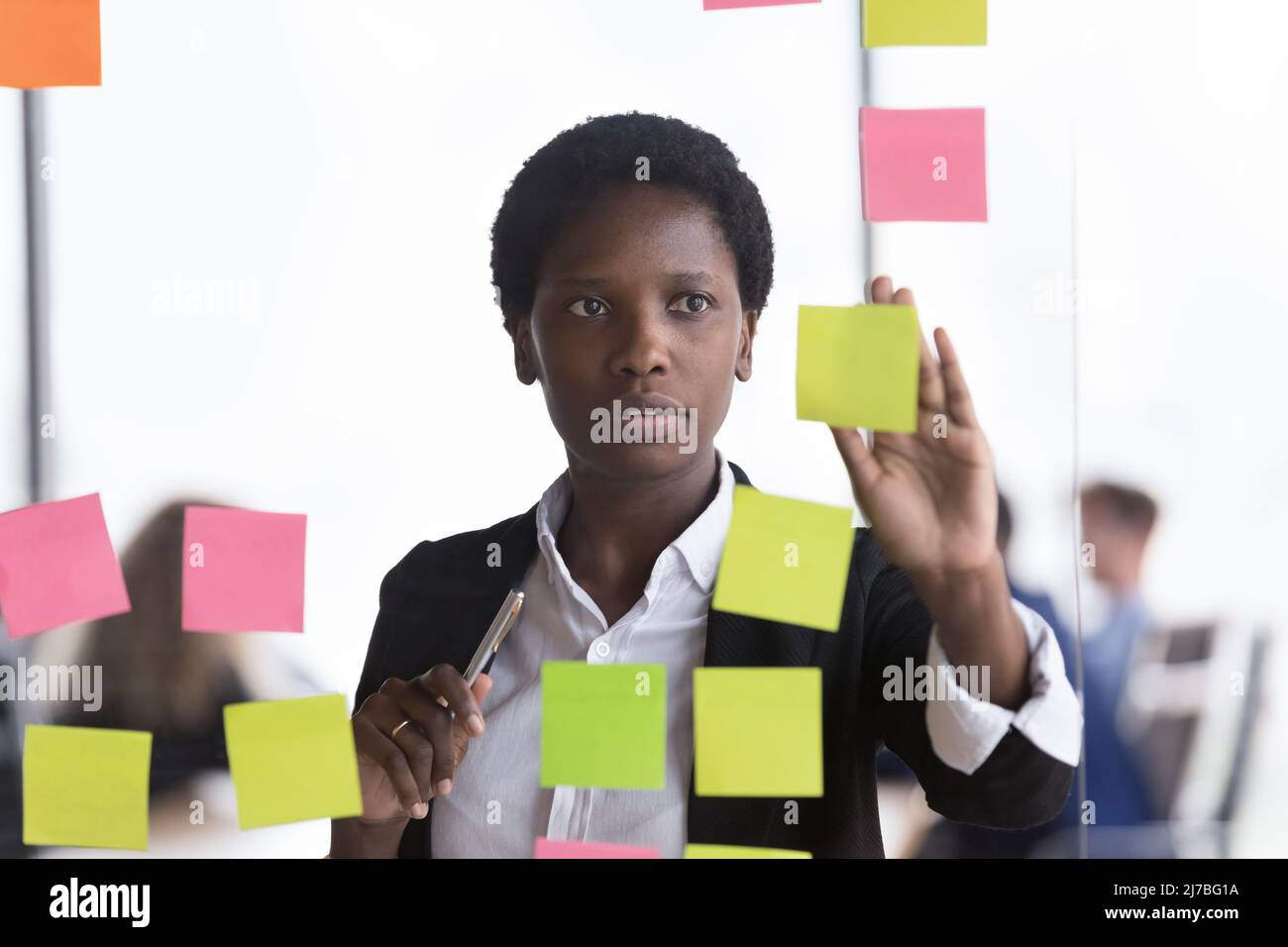 Konzentrierter, vielbeschäftigter afrikanischer Mitarbeiter mit Scrum-Methode und Task-Management-Tools Stockfoto