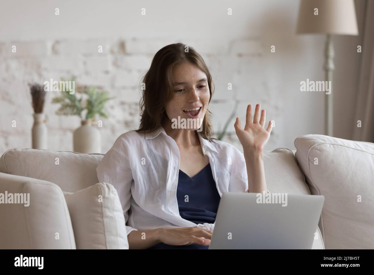 Glücklich fröhlich Laptop Benutzer Mädchen winken Hand hallo an webcam Stockfoto