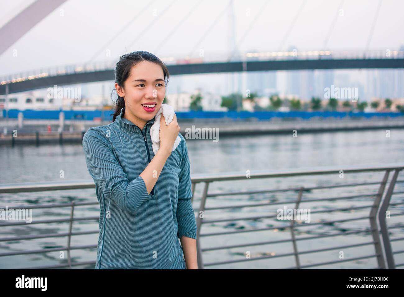 Fit asiatische Frau, die sich von einem Outdoor-Workout ausruhen und draußen in Dubai laufen Stockfoto