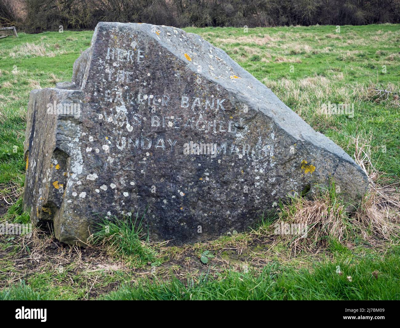 Stein zur Markierung der Stelle, an der am Sonntag, dem 16.. März 1947, in der Nähe von Earith, Cambridgeshire, die Barriere am Ufer des Flusses Great Ouse gebrochen wurde Stockfoto