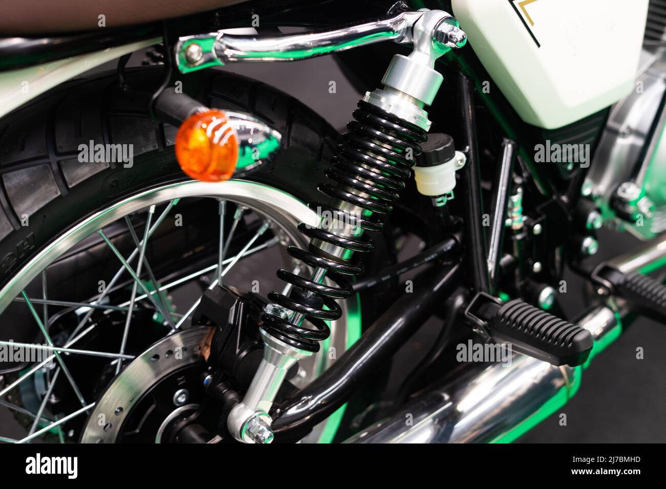 Detail der Fahrwerksfedern und Blinker am Hinterrad eines Custom Motorrads Stockfoto