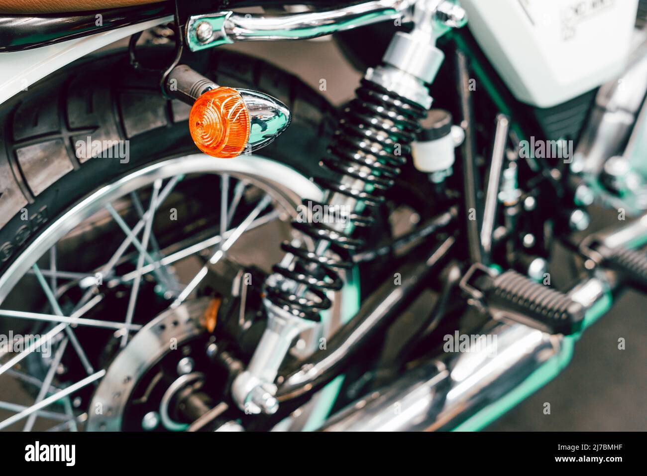 Detail der Fahrwerksfedern und Blinker am Hinterrad eines Custom Motorrads Stockfoto