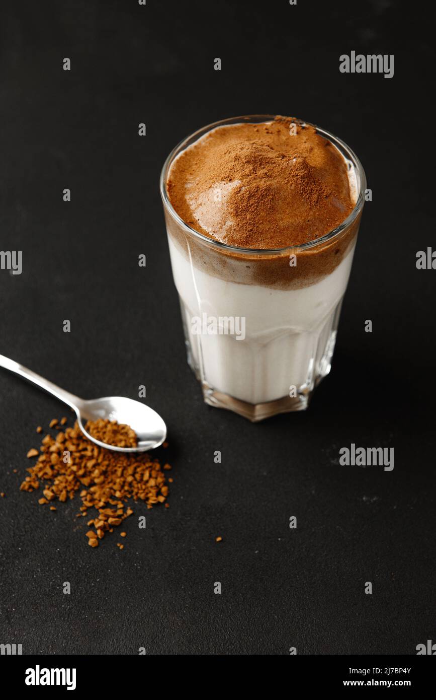 Dalgona Kaffee auf dem dunklen Hintergrund mit Kaffee Stockfoto