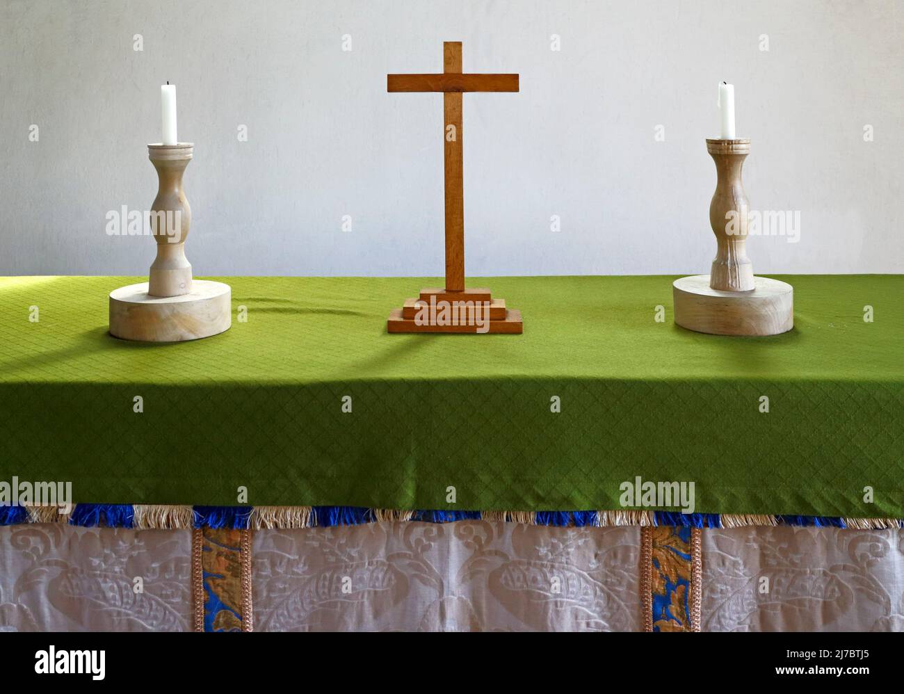 Zwei hölzerne Kerzenständer und ein Holzkreuz auf dem Altartisch in der St. Andreas-Kirche in Lamas, Buxton mit Lamas, Norfolk, England, Großbritannien. Stockfoto