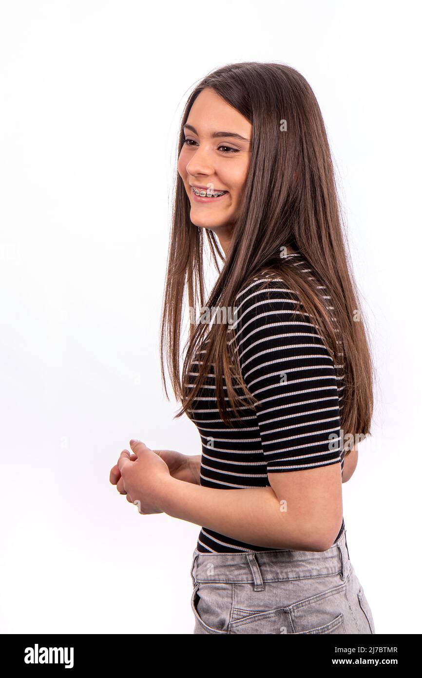 Portrait von schönen lächelnden Mädchen mit langen Haaren. Die junge Frau trägt Jeans und ein gestreiftes T-Shirt. Stockfoto