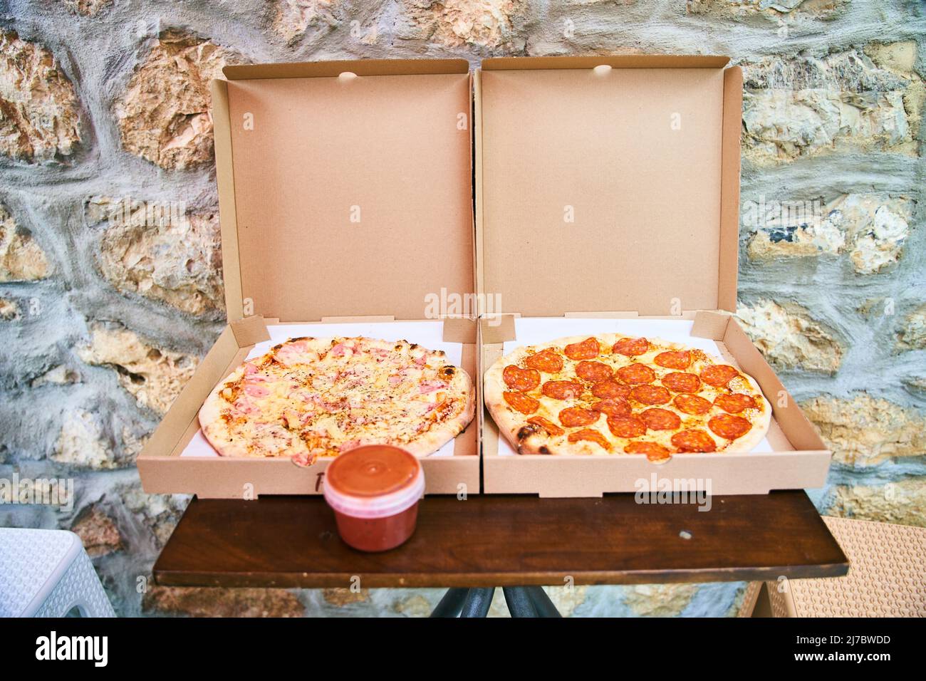 Zwei frische Pizzas Schinken mit Pilzen und Pepperoni in einer Schachtel. Stockfoto