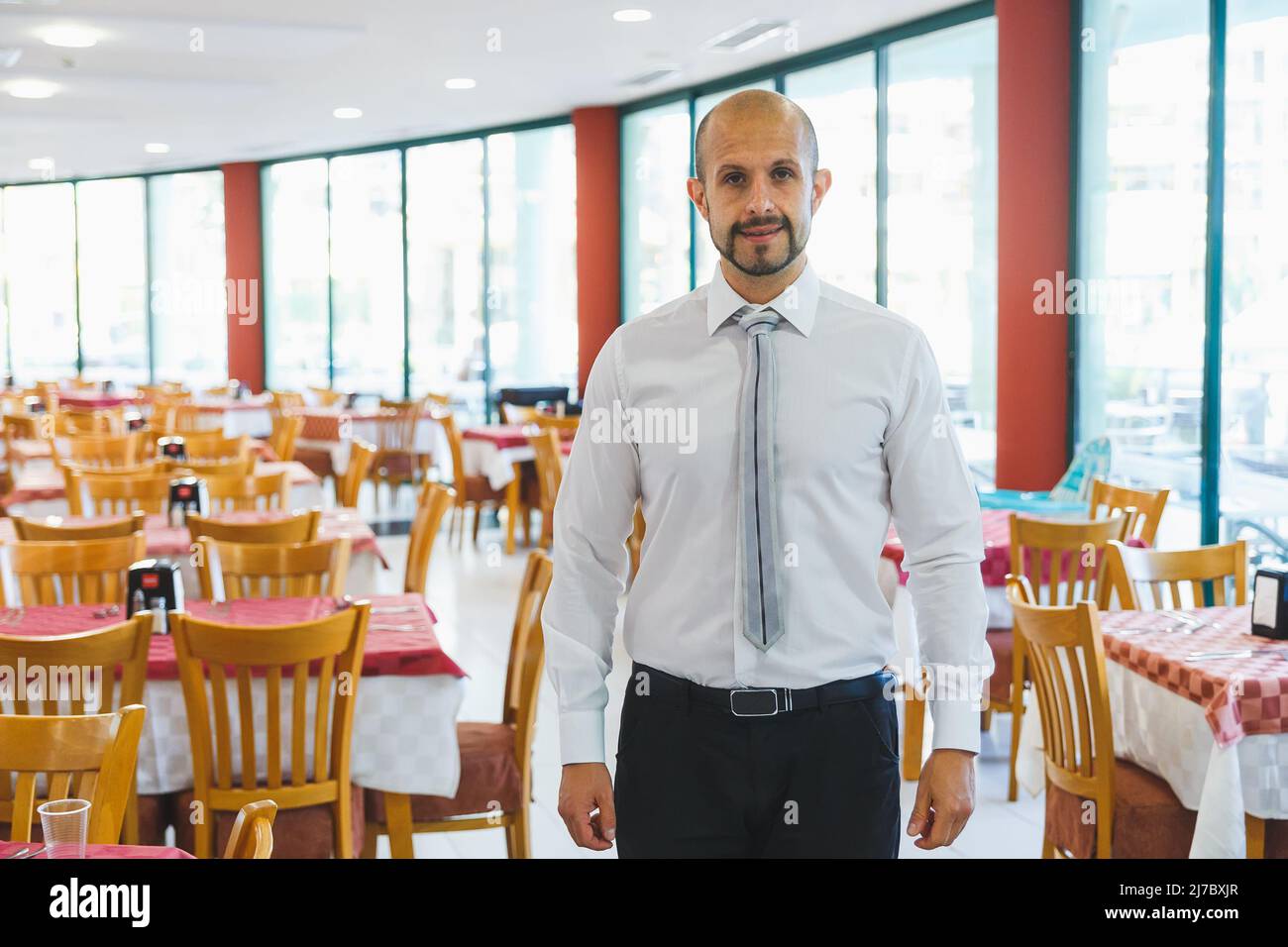 NESSEBAR, BULGARIEN - 26. August 2017: Junger, gutaussehender Verwalter, der im Restaurant des Hotels steht und Besucher trifft Stockfoto