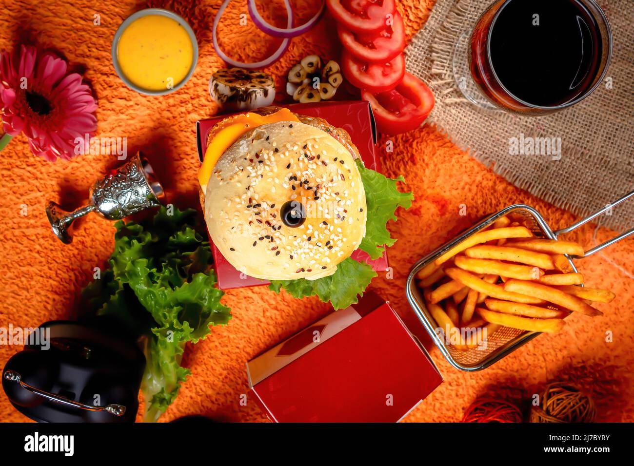 Tongue Twister Beef Naga Burger mit Pommes Frites und Tomatenscheibe isoliert auf Holzbrett Seitenansicht der amerikanischen Street Food Stockfoto