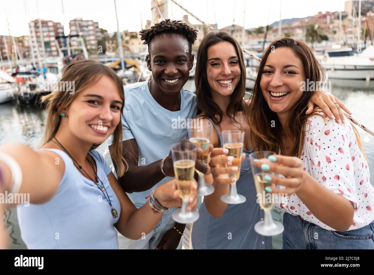 Eine Gruppe von Menschen aus verschiedenen Rassen, die gemeinsam Champagner auf dem Boot trinken Stockfoto