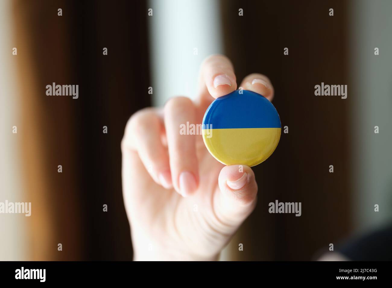 Person hält runde Abzeichen Flagge der Ukraine Nahaufnahme Stockfoto