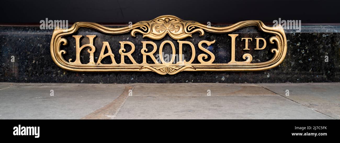 London, Großbritannien - 17. April 2022: Harrods-Schild auf dem Boden des Art déco-Messingpflasters an der Außenseite des berühmten Londoner Kaufhauses Knightsbridge, London. Stockfoto