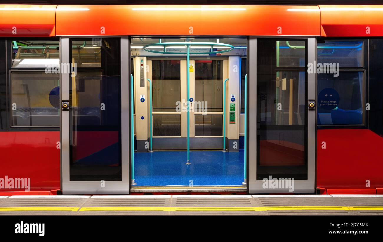 Allgemeiner Zug in Londoner U-Bahntunneln. An der Plattform steht ein leerer Wagen mit offenen Türen. Von Millionen Touristen und Pendlern genutzt. Stockfoto