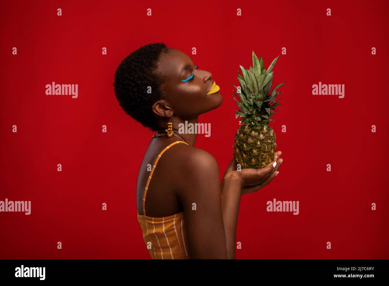 Profilportrait einer afroamerikanischen Frau mit Ananas Stockfoto