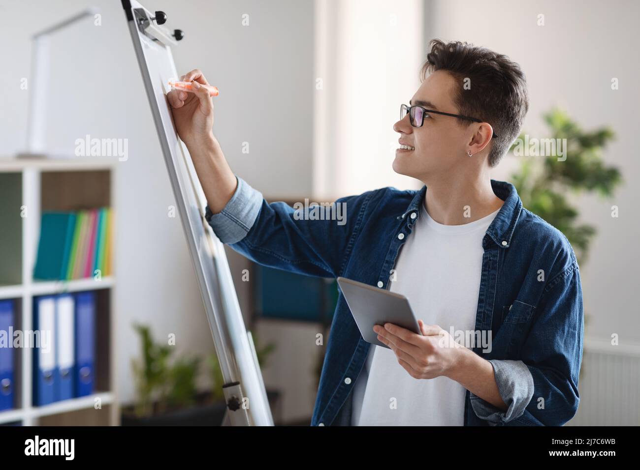 Startplanung. Junge Männliche Unternehmer Holding Digital Tablet Und Schreiben An Bord Stockfoto