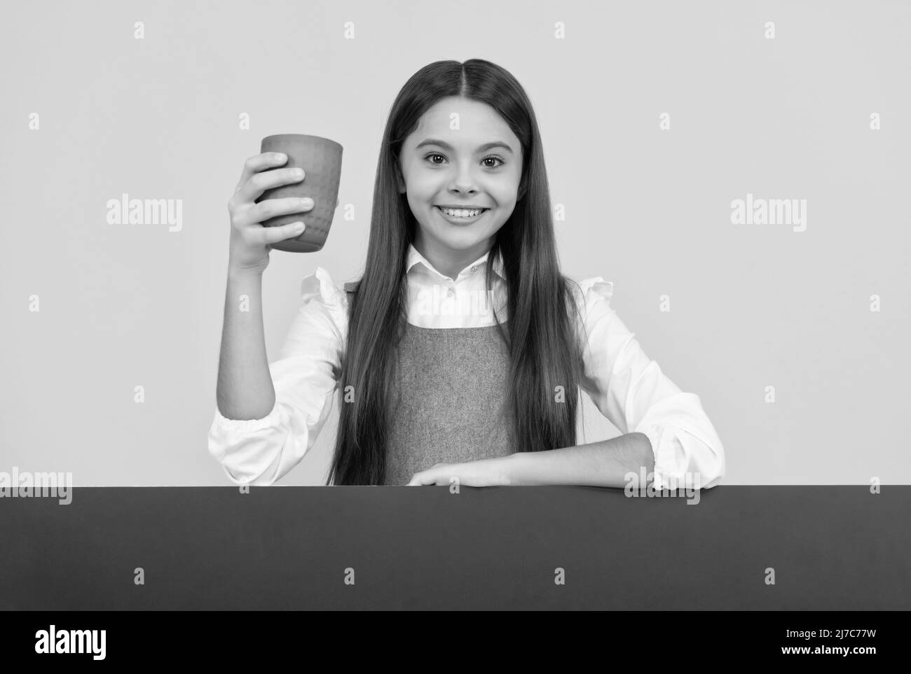 Glücklich Tween Mädchen halten Kunststoff-Tasse mit Getränk und Werbung Board für Copy Space, trinken Stockfoto