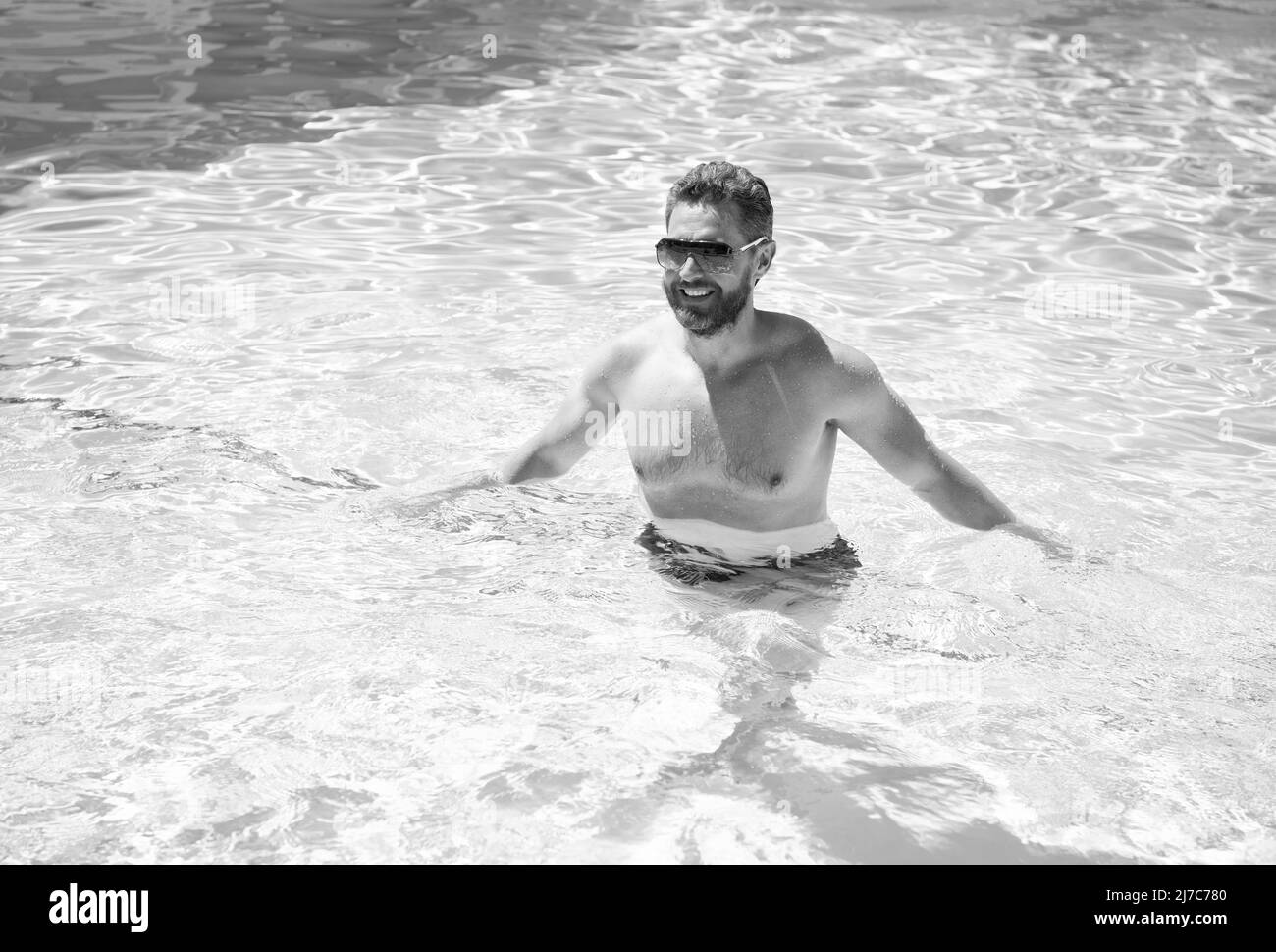 Sommer Spa Resort Urlaub. Glücklicher, gutaussehender Mann im Schwimmbad. Poolparty. Stockfoto