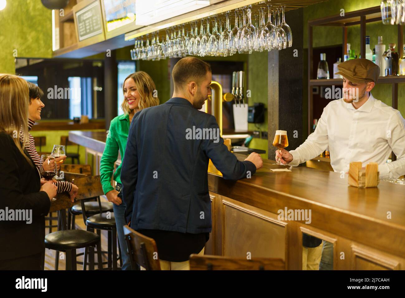 Gäste und Barkeeper in einer eleganten Bar Stockfoto