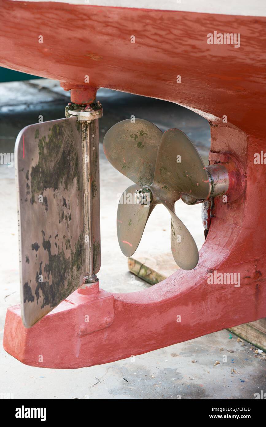 Nahaufnahme des unteren Teils eines roten Bootes aus dem Wasser. Propeller und Ruder. Asturien Stockfoto