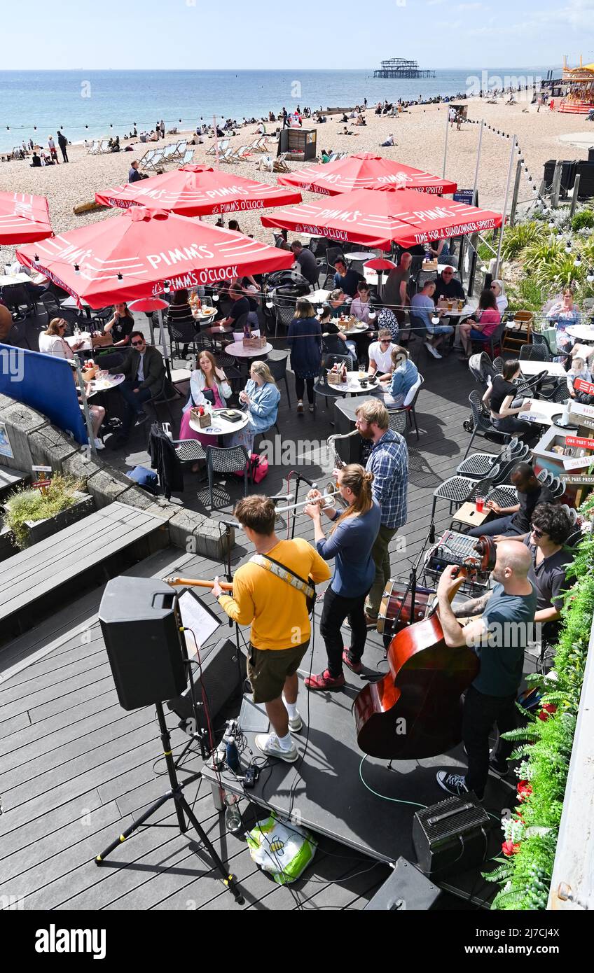 Brighton UK 8. May 2022 - die Strandbars und Restaurants sind voll, da Besucher einen heißen, sonnigen Tag am Brighton Beach genießen, da die Temperaturen in einigen Teilen Großbritanniens voraussichtlich über 20 Grad erreichen werden : Credit Simon Dack / Alamy Live News Stockfoto