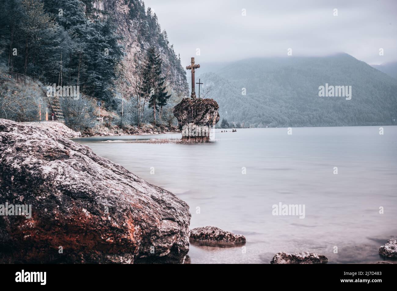 Der Kreuzstein ist ein Felsblock in der Gemeinde Mondsee im Bundesland Oberösterreich. Es liegt im flachen Wasser des Mondsees Stockfoto