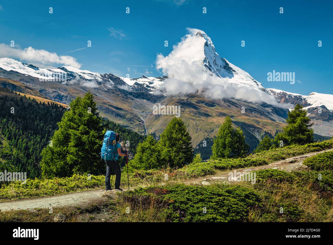 Aktive Wanderfrau mit Rucksack auf dem majestätischen Wanderweg in den Bergen, der Schweiz, Europa Stockfoto