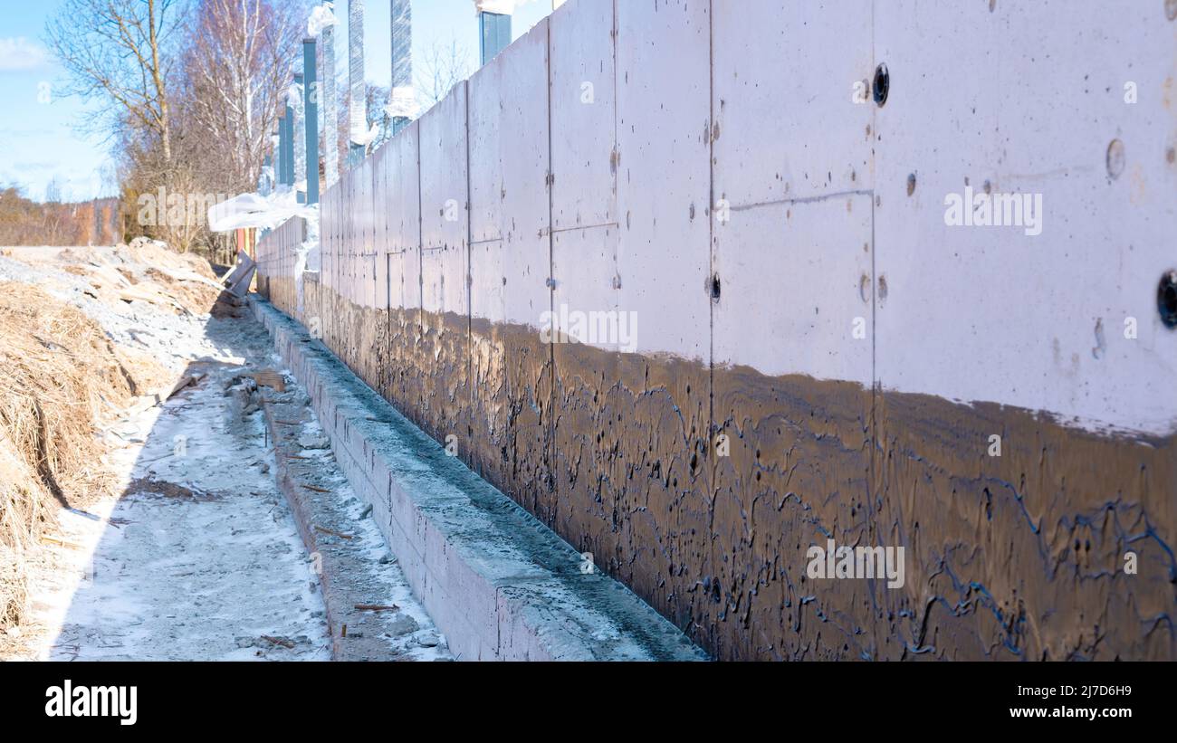 Fundamentabdichtung. Haus Fundament Wand wasserdicht mit Bitumenspray  Stockfotografie - Alamy