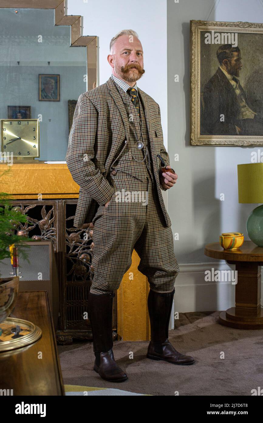 Gut gekleideter, altmodischer englischer Gentleman in seinem Wohnzimmer, der zur Kamera schaut Stockfoto