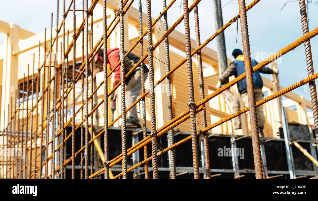 Band Eisen rebar Nahaufnahme. Vor dem Betonieren auf der Baustelle wird die Bewehrungsstange gebindet. Arbeiter Beton eine Stützmauer am Bau Stockfoto