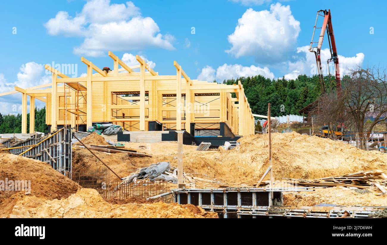 Bau eines Holzhauses aus geklebtem Schichtholz. Baustelle für Doppelbalkenhäuser. Betonieren der Stützmauer, Zaunfundament durch Konz Stockfoto