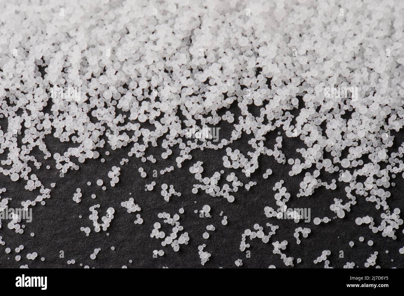 Weiß viele Polymergranulate auf schwarzem matten Hintergrund Stockfoto