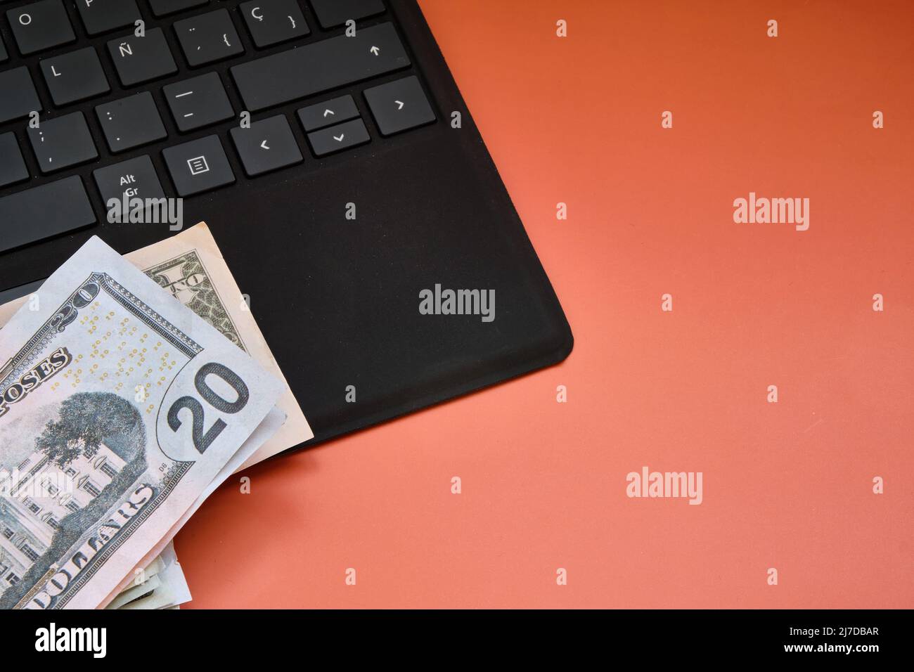 Dollar-Banknoten und schwarze Laptop-Tastatur als Hintergrund. Speicherplatz kopieren. Stockfoto