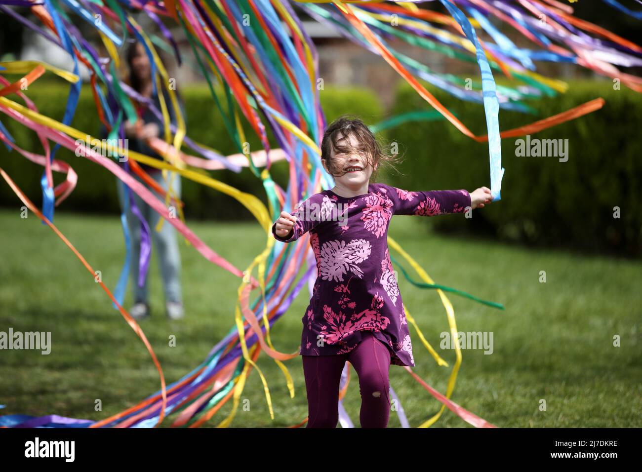 Maayan Romanowski, 6, spielt beim Spring BloomFest im Stevens-Coolidge House and Gardens am Muttertag in North Andover, Massachusetts, USA, am 8. Mai 2022 mit Bändern, die an einem Baum hängen. REUTERS/Reba Saldanha Stockfoto