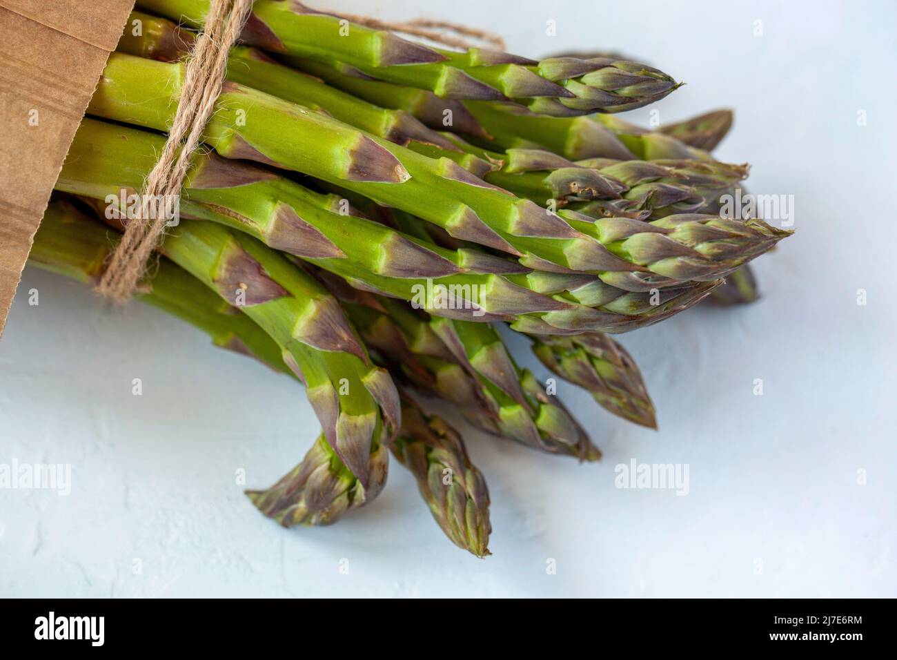 Bund frischer Spargel diagonal auf dem hellblauen Hintergrund Stockfoto