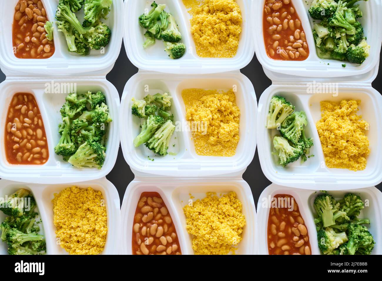 Background consisting of white plastic containers with fresh cooked food on table prepared by volunteers for migrants or homeless people Stockfoto