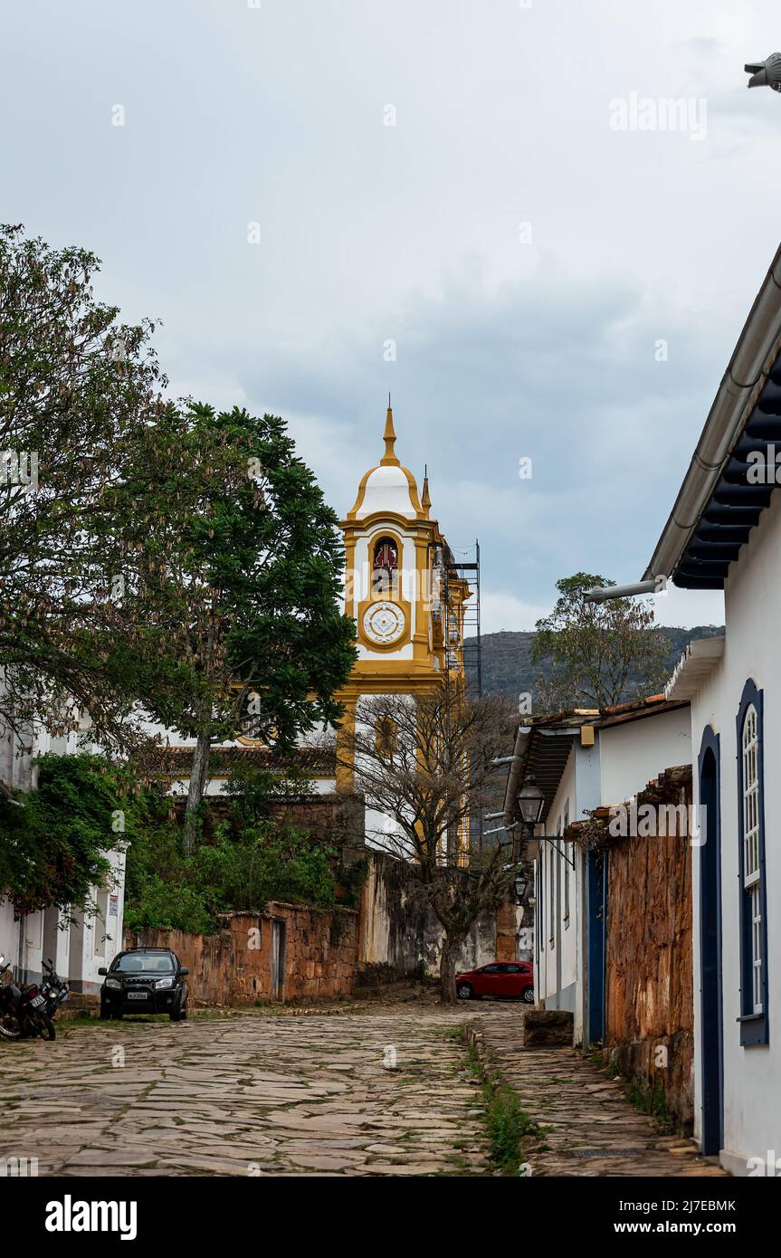 Die bergauf gepflasterte Padre Toledo Straße mit Teilblick auf den Santo Antonio Mutter Kirchturm hinten im historischen Zentrum von Tiradentes. Stockfoto