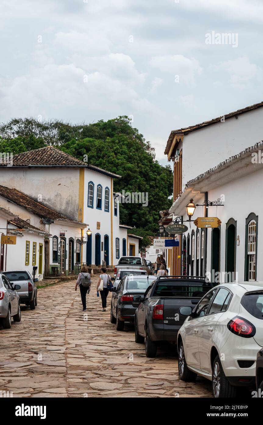 Koloniale Gebäude nebeneinander in der Direta Straße mit Autos in der Nähe in Tiradentes historischen Zentrum unter bewölktem Himmel geparkt. Stockfoto