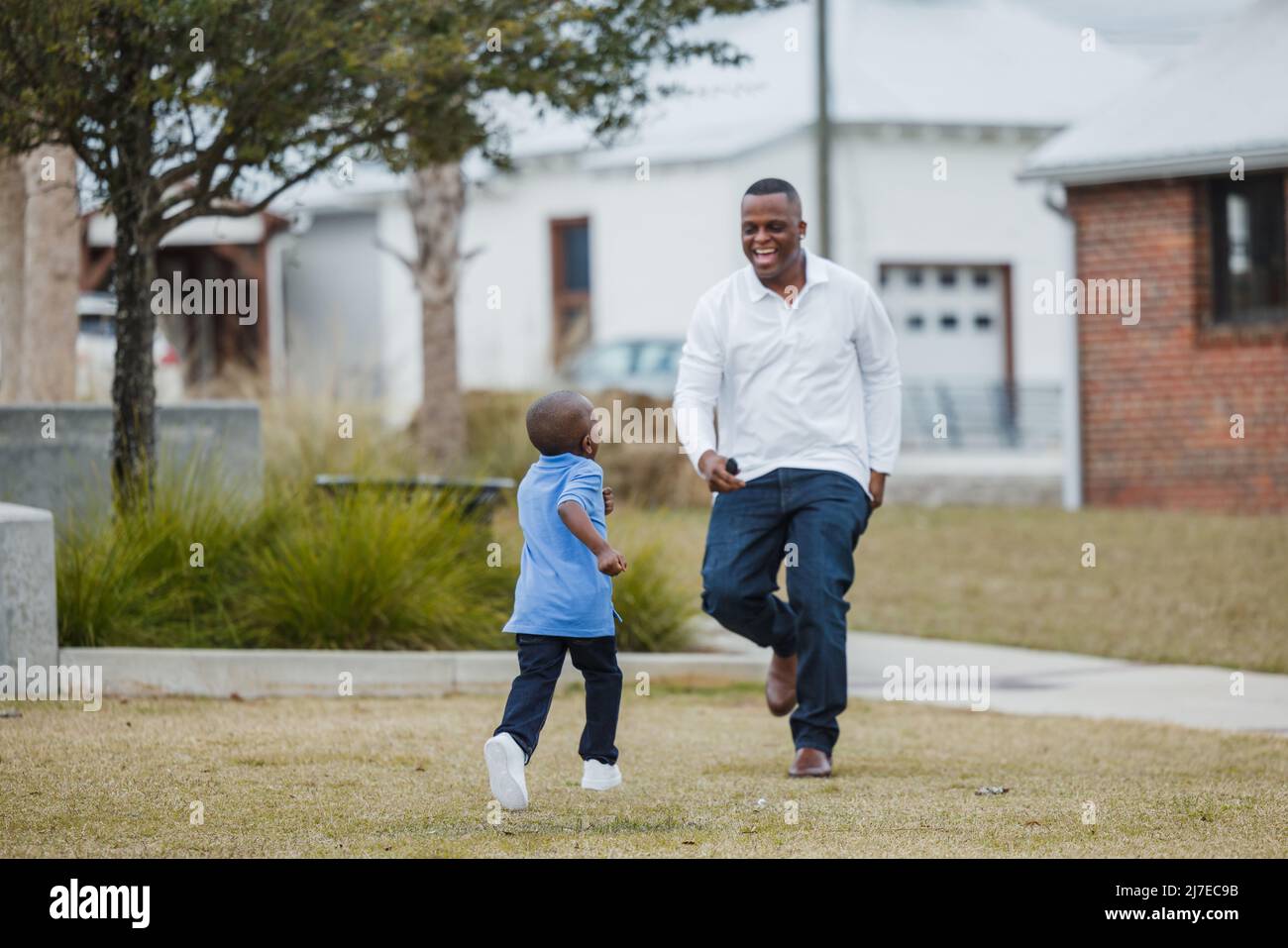 Ein Sohn im Vorschulalter läuft zu seinem Vater, um abgeholt zu werden Stockfoto